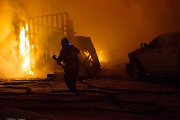 A Kitimat, BC, firefighter battles stubborn flames at a house fire on Whittlesey Street, March 2. 2013 No one was injured. (Robin Rowland)